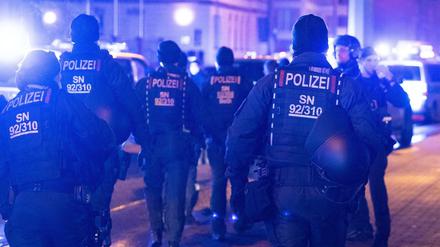 Dresdner Polizisten stehen während eines Protest von Kritikern gegen die Corona-Maßnahmen an einer Straße. 