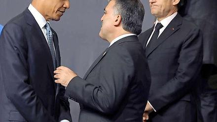 Der türkische Präsident Abdullah Gül unterhält sich auf dem Natogipfel mit Barack Obama, Nicolas Sarkozy schaut skeptisch.