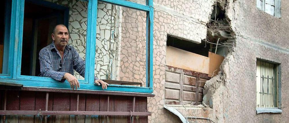 Ein Mann in Slowjansk in der Ost-Ukraine blickt nach einem Bombardement aus seinem Haus, um den Schaden zu begutachten.