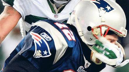 Leaving on a Jet Plane. Patriots-Quarterback Tom Brady wird von Jets-Cornerback Drew Coleman gestoppt. Foto: dpa