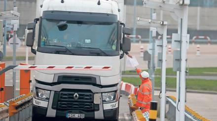 Papierstau. Am Eurotunnel kontrollieren Mitarbeiter die Dokumente der Lastwagenfahrer. Foto: Frank Augstein/dpa