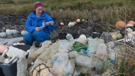 Die Forscherin Maelle Connan untersucht Plastikflaschen auf Inaccessible Island.