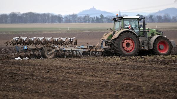 Ein Traktor zieht einen Pflug über ein Feld nahe Gotha in Thüringen. 