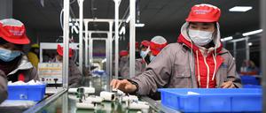 Menschen arbeiten in einer chinesischen Fabrik (Symbolbild)..