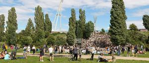 Menschen haben sich an einem Sommertag im Mauerpark versammelt. 