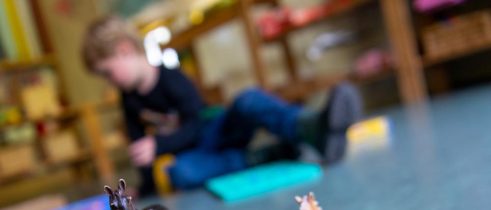 Ein Junge spielt in einem Brandenburger Kindergarten auf dem Boden. 