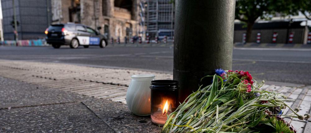 Kerzen und ein Blumenstrauß liegen auf dem Bürgersteig an der Tauentzienstraße.