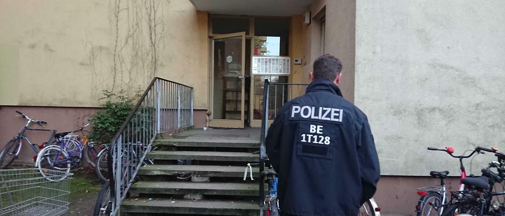 Ein Polizist steht vor dem Eingang des Wohnhauses, in dem der Terrorverdächtige lebte.