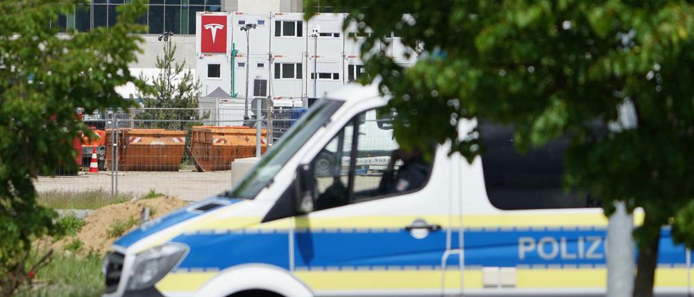 Ein Polizeiauto steht in Sichtweite der Tesla-Baustelle bei Grünheide.