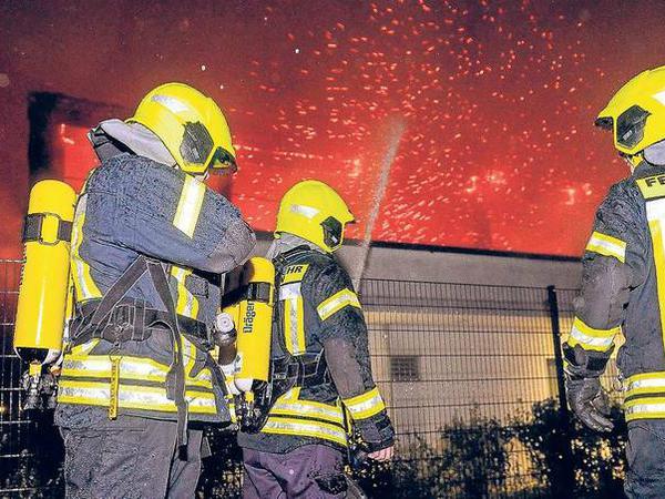 Feuerwehrleute versuchen am 25. August 2015, den Brand in einer Sporthalle und geplanten Notunterkunft in Nauen unter Kontrolle zu bringen.