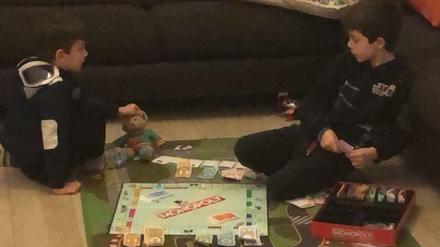 Immer zuhause. Rafael und Leonardo, fünf und sieben Jahre alt, spielen Monopoly