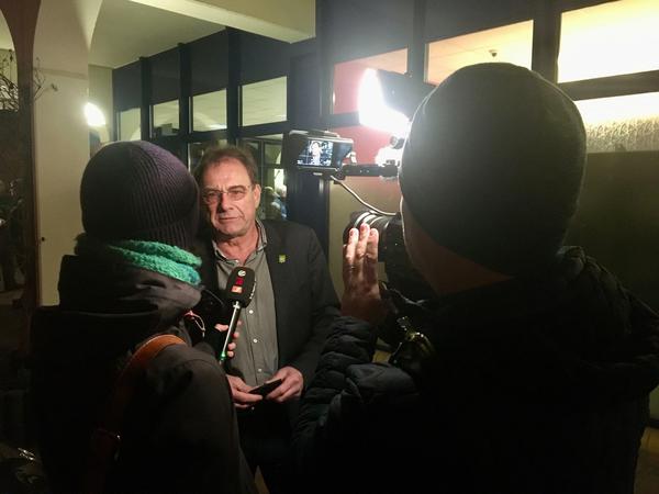 Grünheides Bürgermeister Arne Christiani (parteilos) gibt am Donnerstagabend Interviews vor Teslas temporärem Bürgerbüro.