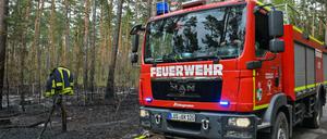 Ein Löschfahrzeug der Freiwilligen Feuerwehr steht neben einem gelöschten Waldbrand in Briesen. Mit den steigenden Temperaturen hat in Brandenburg die Gefahr von Waldbränden stark zugenommen.