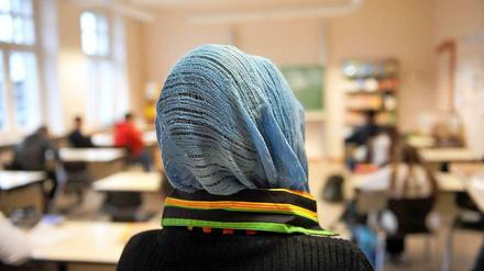 Eine muslimische Schülerin im Unterricht. Das Tragen von Kopfbedeckungen im Unterricht dürfen Schulen nicht verbieten.