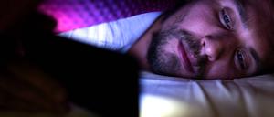  Bearded young man is lying in bed under his blanket looking at phone Wlodawa, Lubelskie, Poland PUBLICATIONxINxGERxSUIxAUTxONLY CRQLKC191113B-234673-01 Gut schlafen Hannes Soltau
