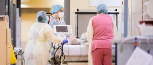 Eine Assistenzärztin schiebt mit Intensivfachpflegerinnen auf der Intensivstation des Gemeinschaftskrankenhauses Krankenbett eines Covid-19-Patienten.