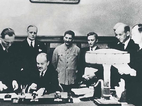 Unterzeichnung. Der deutsche Außenminister Ribbentrop (links neben Stalin) und sein sowjetischer Amtskollege Molotow (sitzend).