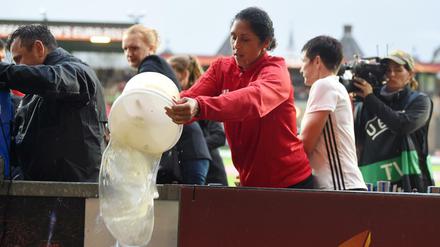 Deutschlands Trainerin Steffi Jones hilft nach Starkregen beim Entwässern des Spielfeldes für das EM-Viertelfinale. 