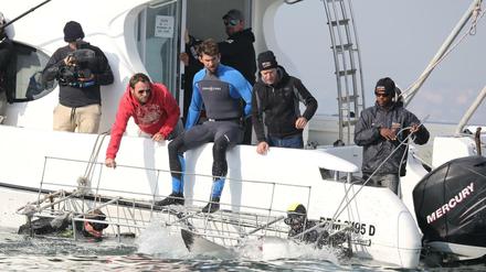 Der ehemalige US-Schwimmstar Michael Phelps (Mitte) sitzt auf einer undatierten Aufnahme vor den Inseln der Bahamas auf dem Boot und bereitet sich auf ein Showrennen gegen einen Weißen Hai vor. Tatsächlich schwamm Phelps dann gegen eine Computeranimation.