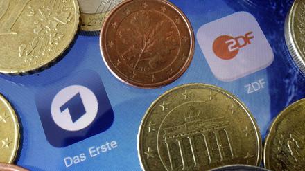 Euromünzen liegen neben den Logos der Apps von ARD und ZDF.