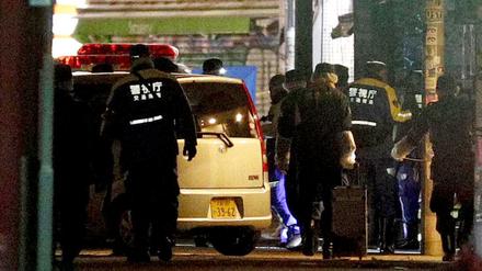 Polizisten inspizieren ein Auto in Tokio, nachdem es mehrere Fußgänger gerammt hat.