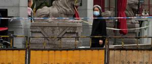 Eine Frau geht während des Lockdowns in Shanghai auf einer gesperrten Straße.