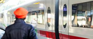 Ein Mitarbeiter der Deutschen Bahn steht neben einem ICE-Zug.
