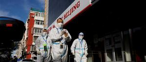 Mitarbeiter der Pandemieprävention in Schutzanzügen (Symbolbild)