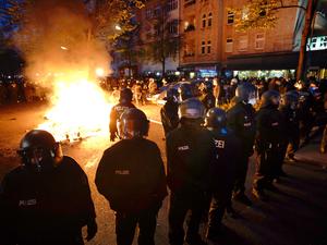 Polizisten stehen am Rande der Demonstration linker und linksradikaler Gruppen unter dem Motto «Demonstration zum revolutionären 1. Mai» im Jahr 2021 vor einem Feuer auf der Straße. (Archivbild)