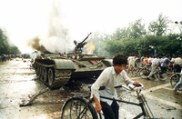 Menschen fliehen vor 30 Jahren vor einem in Brand gesetzten Panzer westlich des Tien An Men-Platzes in Peking.