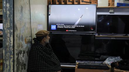 Ein Mann in Pakistan verfolgt auf einem Fernseher die Berichterstattung über die Raketenangriffe.
