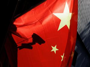 Eine Überwachungskamera hinter einer chinesischen Nationalflagge i Peking.