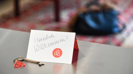 Ein Schlüssel mit einem Airbnb-Anhänger und eine Herzlich-Willkommen-Karte liegen in der Wohnung eines Airbnb-Gastgebers (Gestellte Aufnahme)