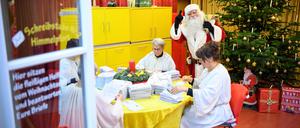 Der Weihnachtsmann steht nach der Ankunft im Weihnachtspostamt neben den vier Engeln, die seine Wunschzettel-Post öffnen und vorsortieren. 