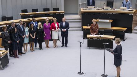 Die neue Regierung (l) wartet auf die Vereidigung durch vor Parlamentspräsidentin Cornelia Seibeld (r) im Saal.