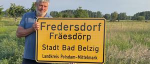 Bodo Sternberg, Ortsvorsteher von Fredersdorf hält das neue Ortsschild in den Händen. 