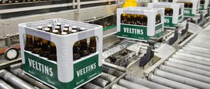 Bierkästen und im Hintergrund Bierflaschen bewegen sich durch die Produktion der Veltins-Brauerei in Meschede-Grevenstein (Nordrhein-Westfalen) über die Förderbänder einer Befüllungsanlage. 