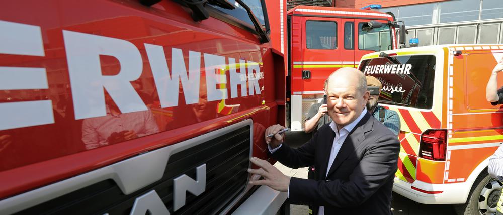 Bundeskanzler Olaf Scholz (SPD) unterschreibt auf einem Feuerwehrauto, das für die Ukraine gespendet wird.