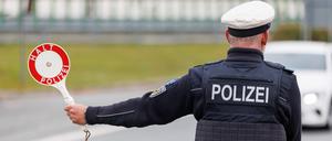 Ein Beamter der Bundespolizei stoppt bei der Kontrolle des Einreiseverkehrs am deutsch-tschechischen Grenzübergang Furth den Fahrer eines Autos bei der Einreise. 