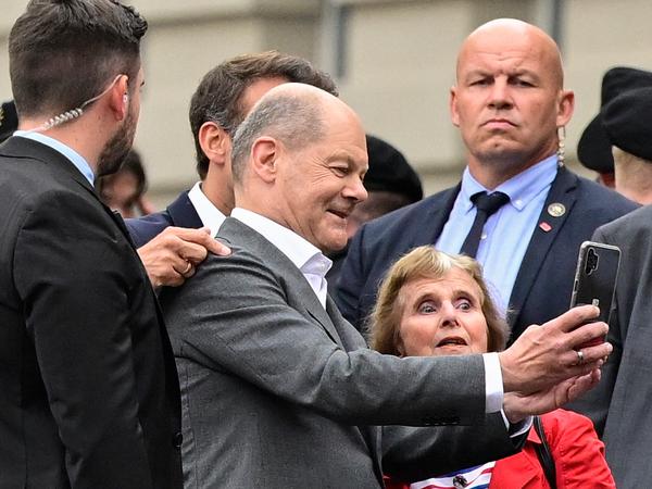 Der Bundeskanzler drückt ab: ein Selfie mit Scholz und Macron für Evelyn Haupt mit deren Handy.