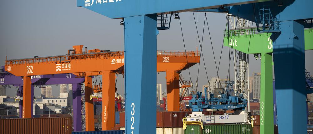 Ein Kran hebt einen Schiffscontainer in einem automatisierten Containerhafen in Tianjin. Vor dem Hintergrund der chaotischen Corona-Lage in China ist die Wirtschaft des Landes nach offiziellen Angaben im vierten Quartal noch um 2,9 Prozent gewachsen.