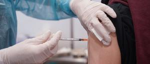 Ein junger Mann wird mit einer Booster-Dosis eines Corona-Impfstoffs gegen das Coronavirus geimpft.