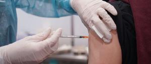 Ein junger Mann wird mit einer Booster-Dosis eines Corona-Impfstoffs im Impfzentrum in der Potsdamer Schinkelhalle gegen das Coronavirus geimpft.