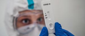 Ein medizinischer Mitarbeiter zeigt einen Corona-Test