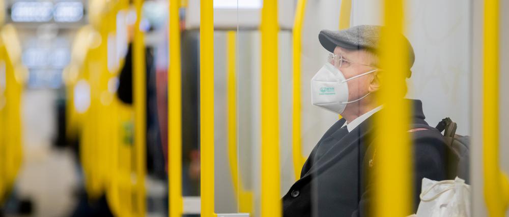Ein Mann sitzt mit FFP2-Maske in der U-Bahn. 