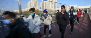 Maskierte Pendler in Peking auf einer Fußgängerbrücke am 8. Dezember