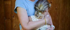 Eine Mutter umarmt ihr Kind.