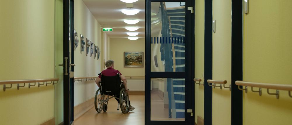 Eine Bewohnerin des Pflegeheims rollt im Rollstuhl durch den Flur Flur im Pflegeheim *** A resident of the nursing home rolls through the hall in a wheelchair 