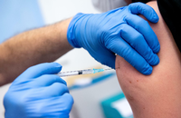 Ein Mann wird von einem Klinikmitarbeiter mit dem Corona-Impfstoff von Biontech/Pfizer geimpft.