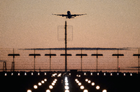 Ein Flugzeug startet vom Flughafen Berlin Brandenburg (BER) in den roten Abendhimmel.